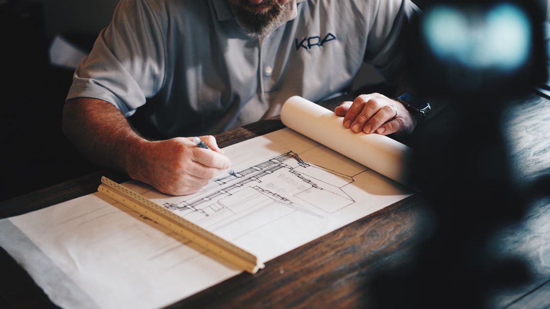 man drawing home designs
